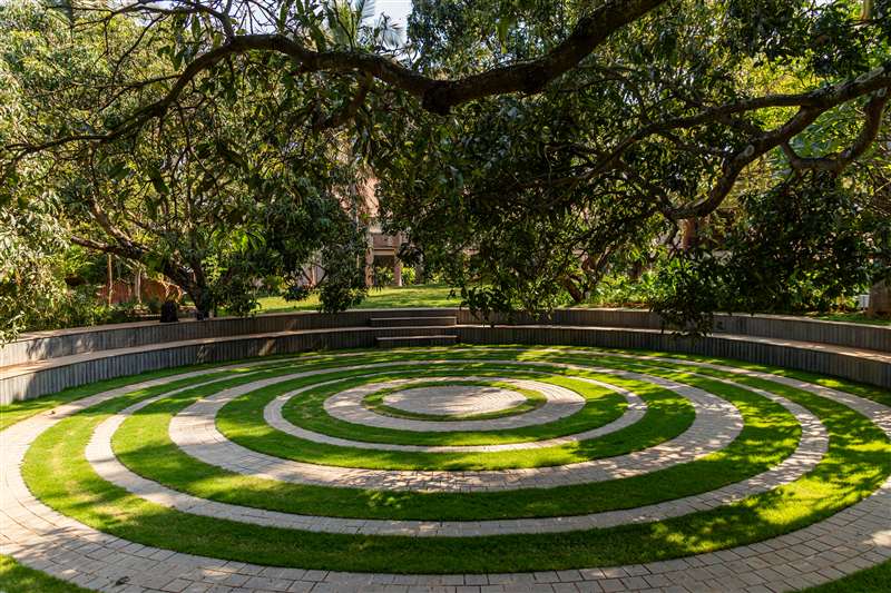 Stone spiral labyrinth garden under canopy trees at Eshanya Estates